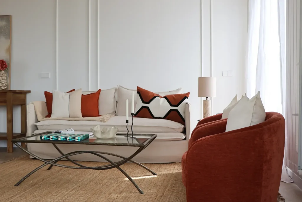 Salón del piso en venta en Menéndez Pelayo 47, Madrid, con sofá, butaca terracota y paredes con molduras